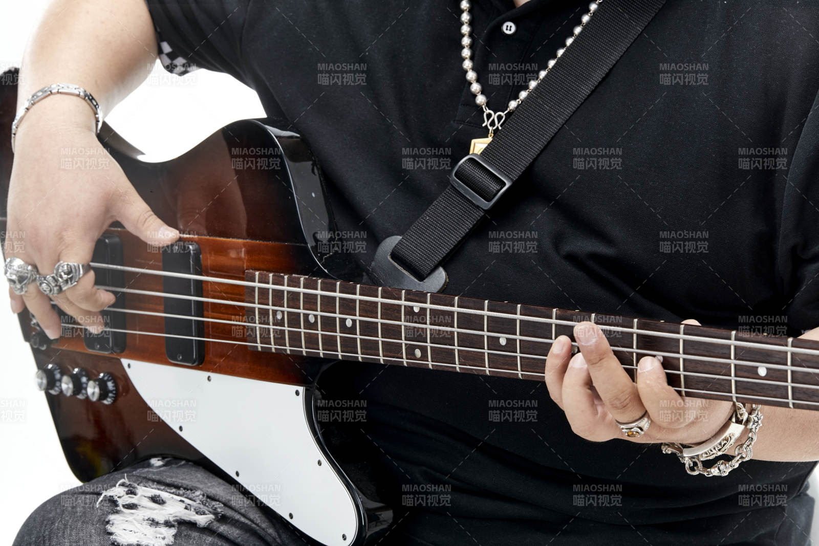 展示贝斯演奏技术技巧的亚洲男性乐手人像局部特写图片