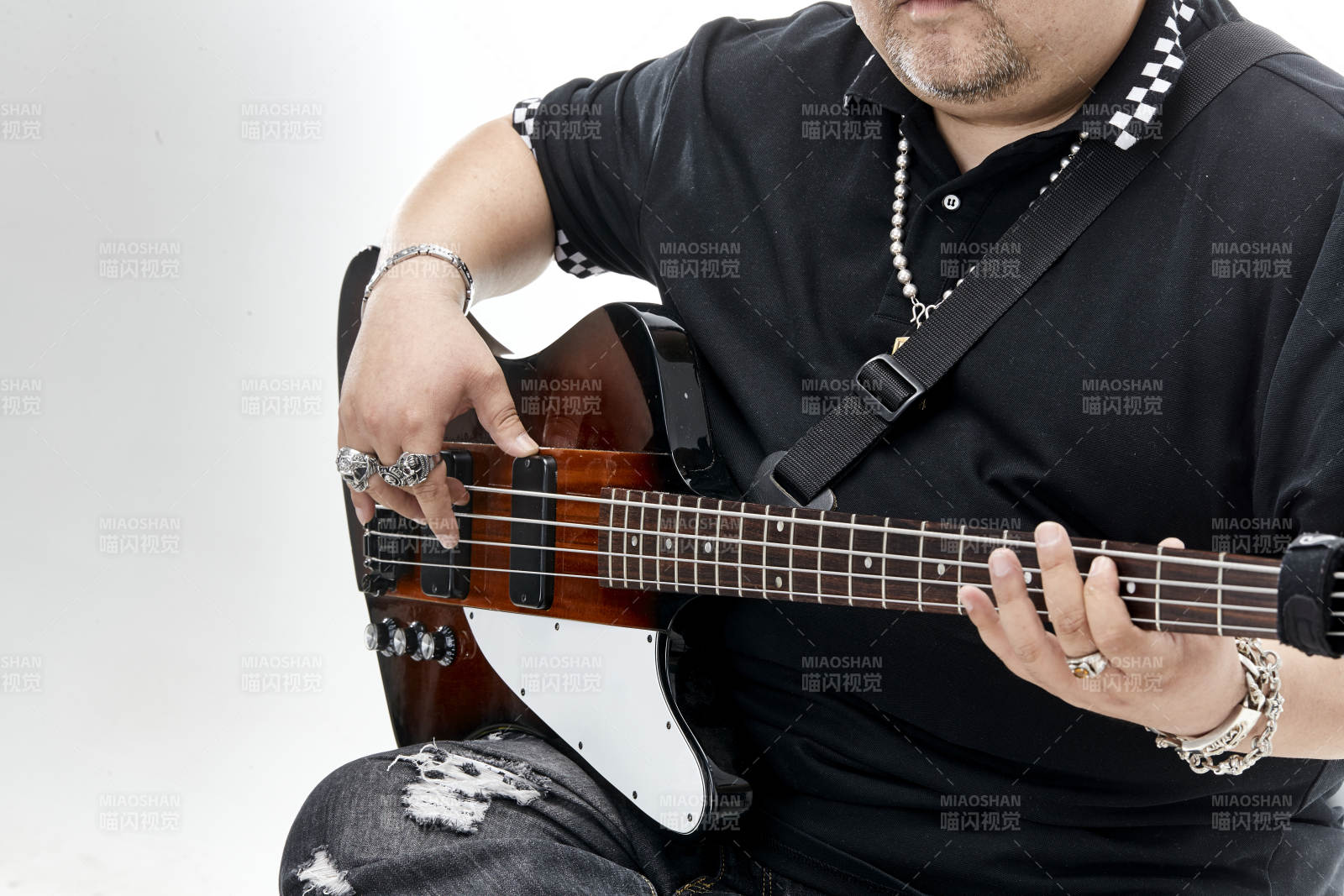 展示贝斯演奏技术技巧的亚洲男性乐手人像局部特写图片