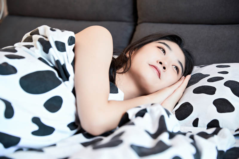 年轻女性睡在在舒适的床上图片