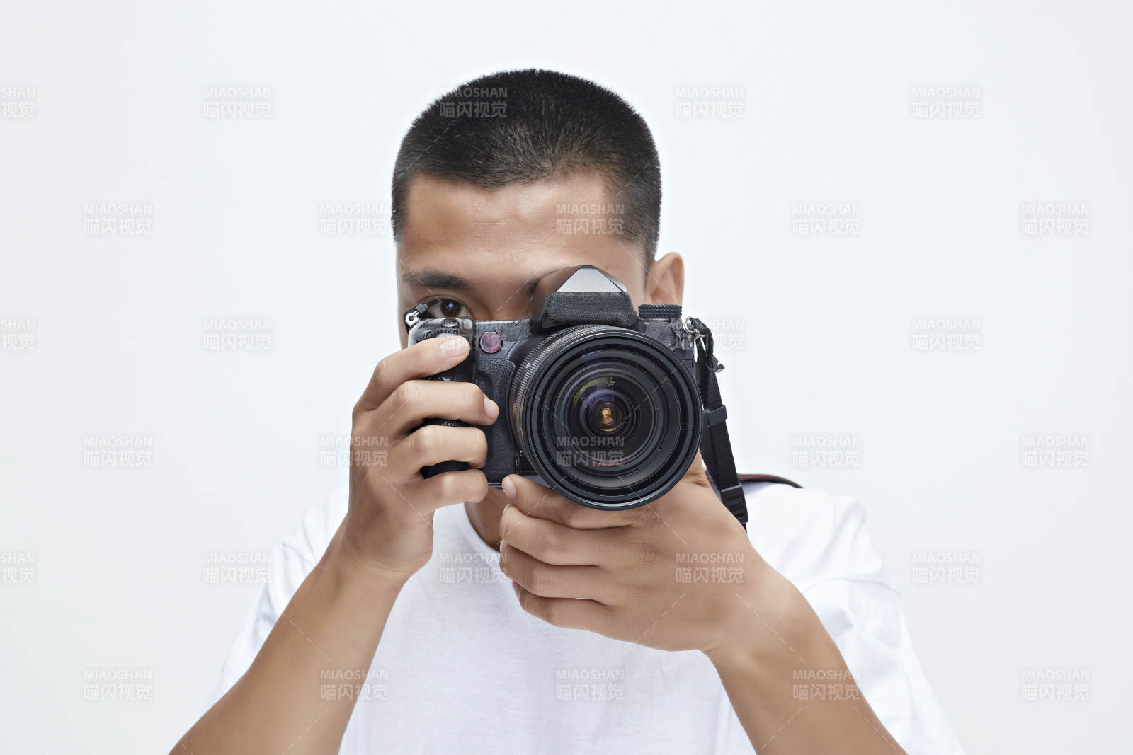 白色背景下手持照相机的亚洲男性摄影师图片