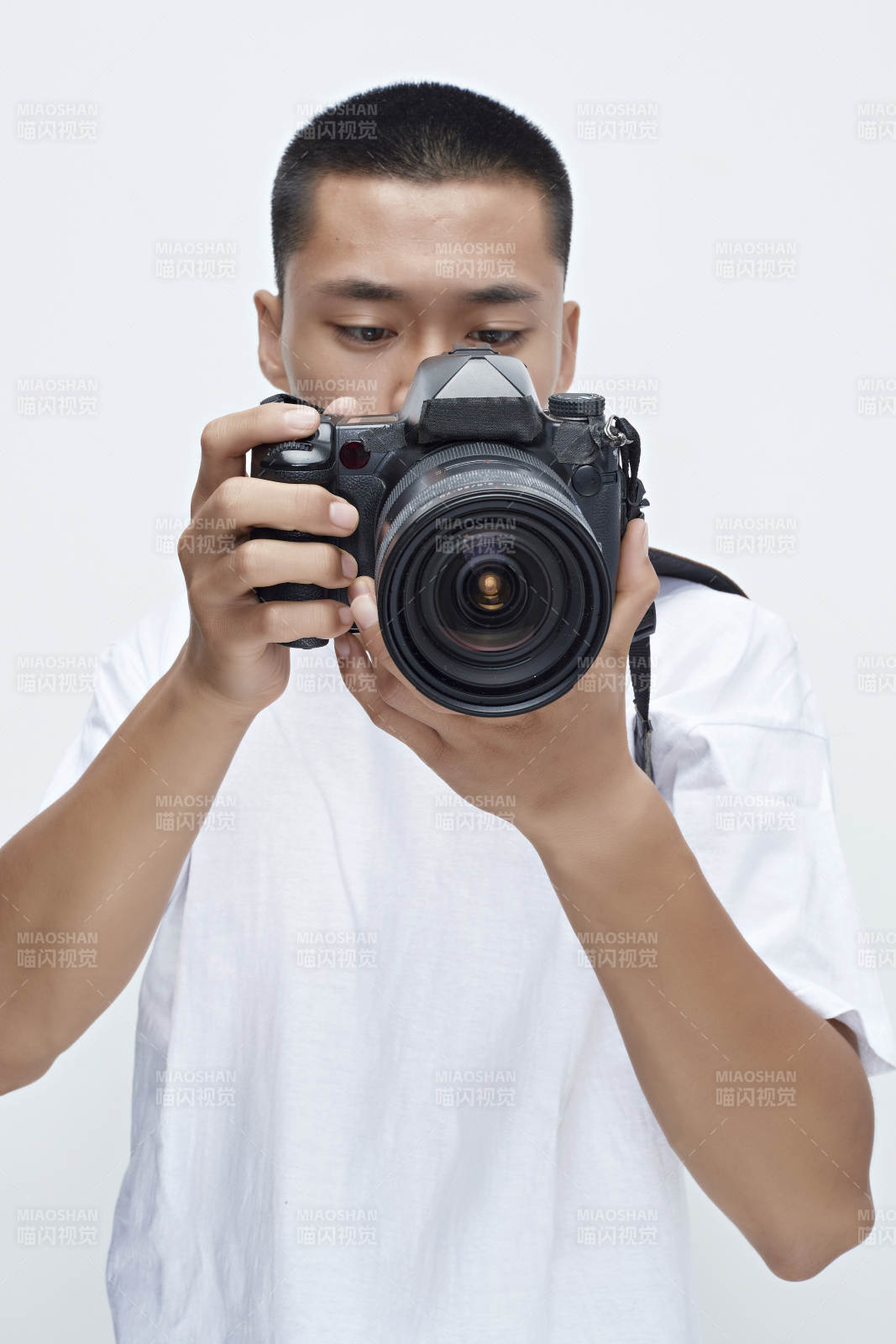 白色背景下手持照相机的亚洲男性摄影师图片
