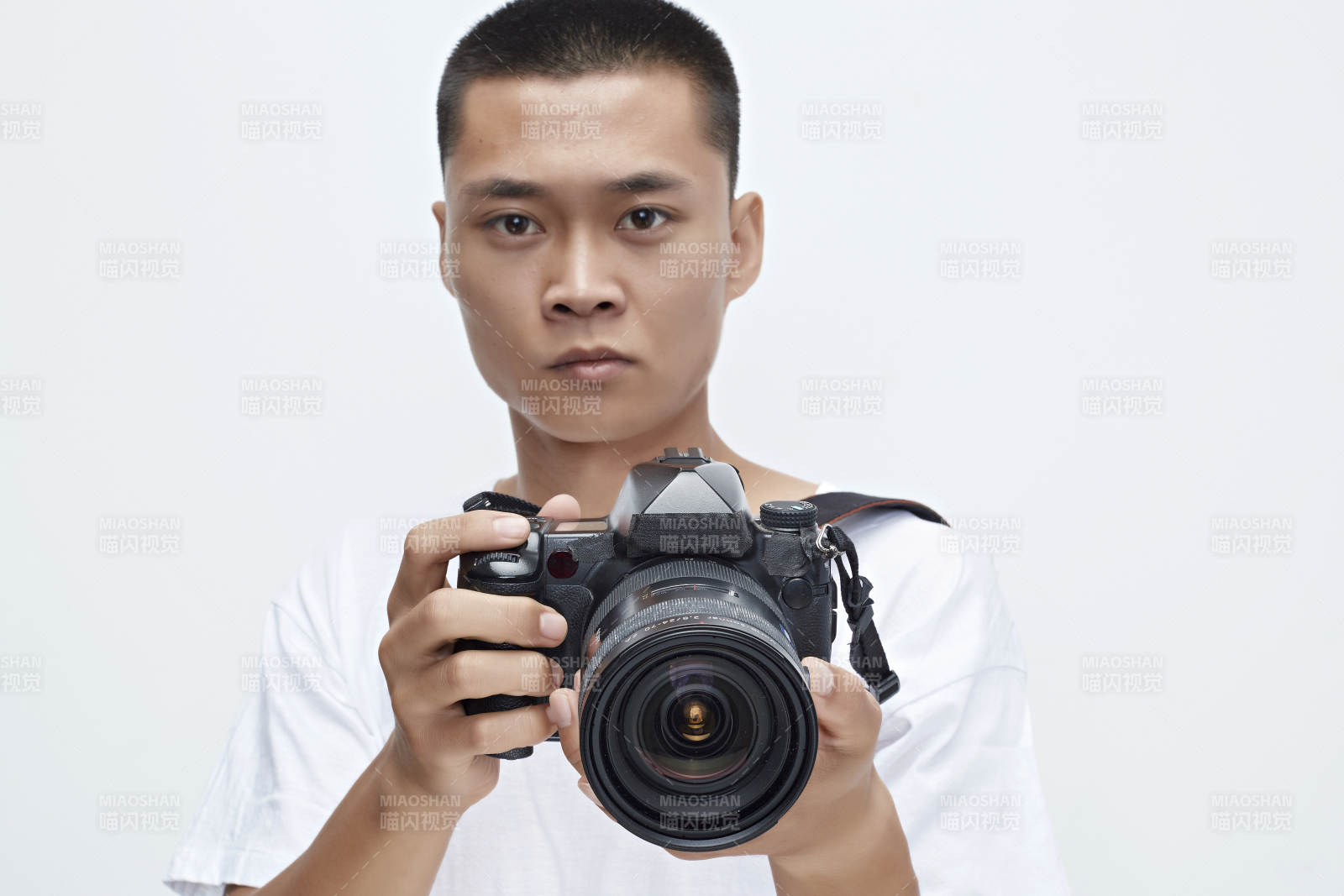 白色背景下手持照相机的亚洲男性摄影师图片