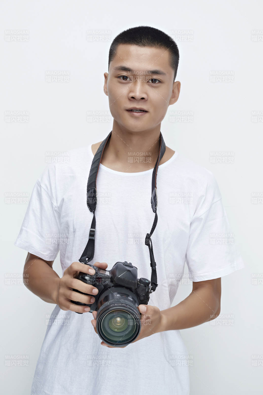 白色背景下手持照相机的亚洲男性摄影师图片