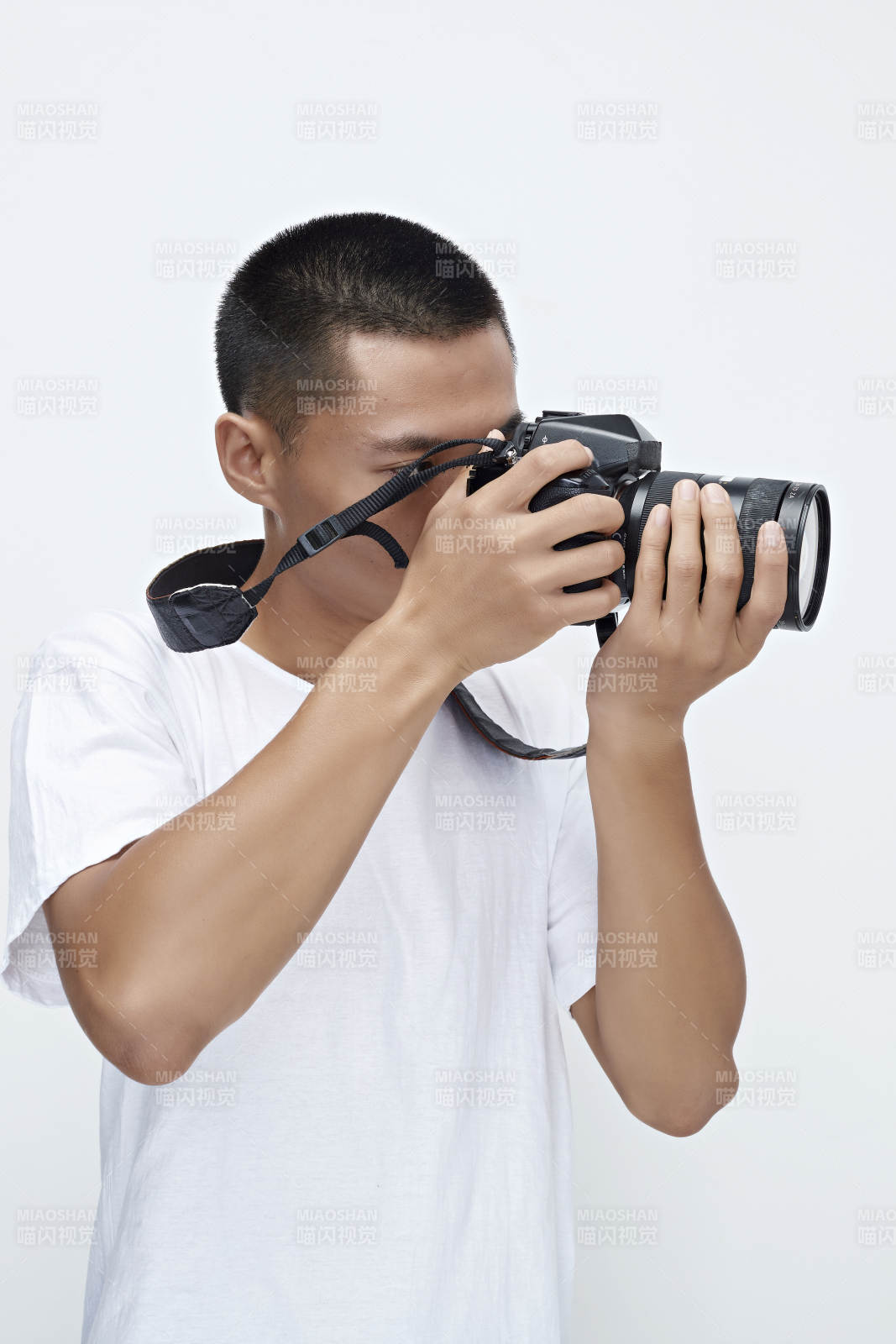 白色背景下手持照相机的亚洲男性摄影师图片