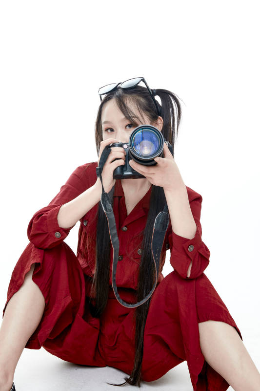 手持相机的亚洲戴墨镜年轻少女的肖像人像图片