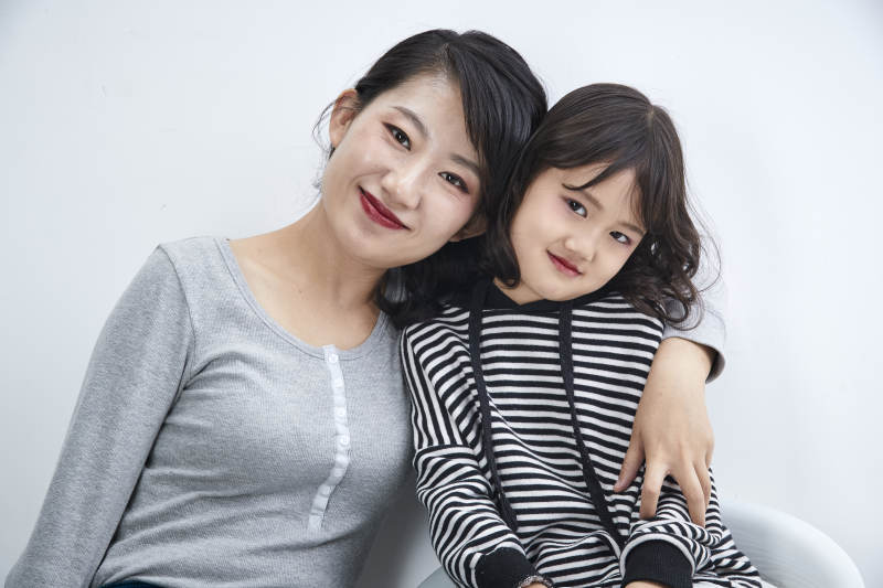 白色背景的美丽妈妈与可爱女儿亲子人像图片