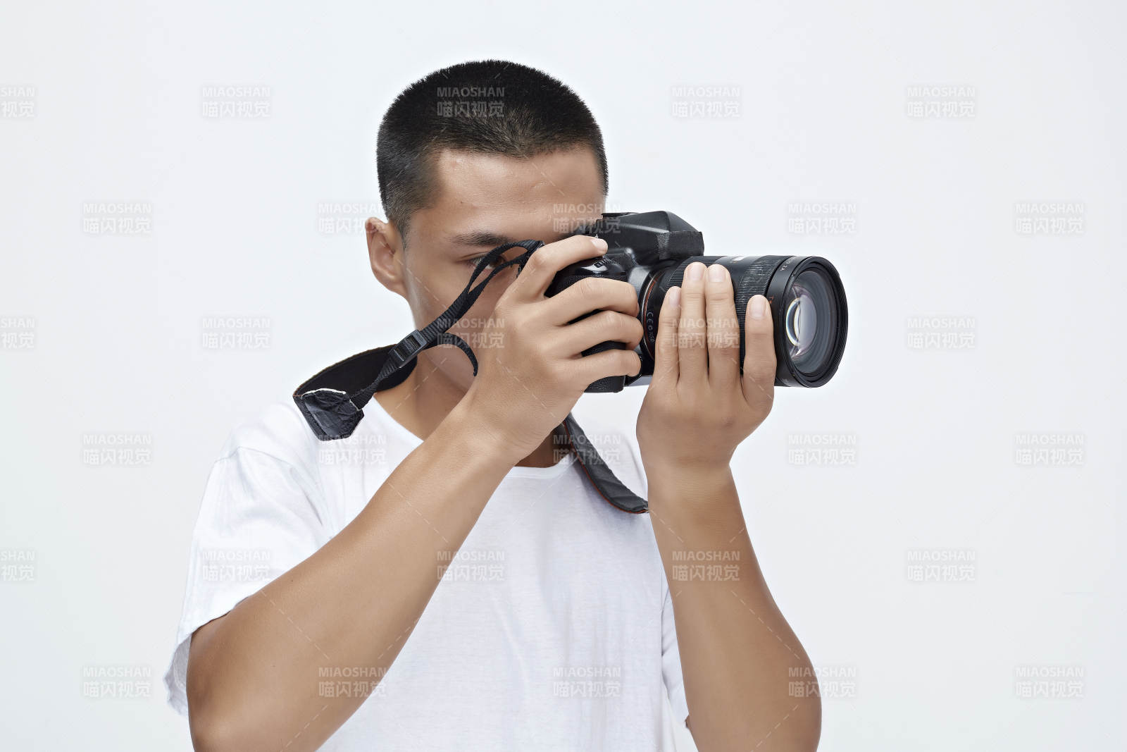 白色背景下手持照相机的亚洲男性摄影师图片