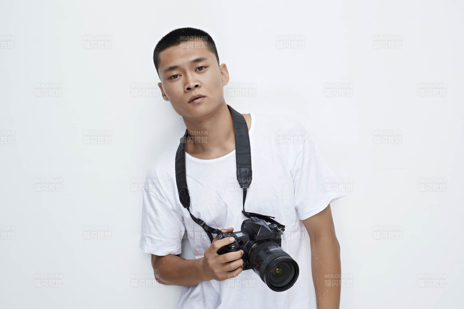 白色背景下手持照相机的亚洲男性摄影师图片