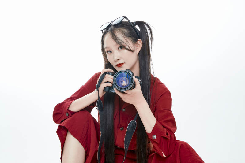 手持相机的亚洲戴墨镜年轻少女的肖像人像图片