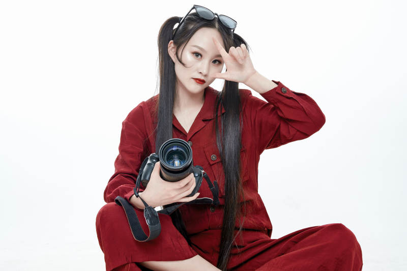 手持相机的亚洲戴墨镜年轻少女的肖像人像图片