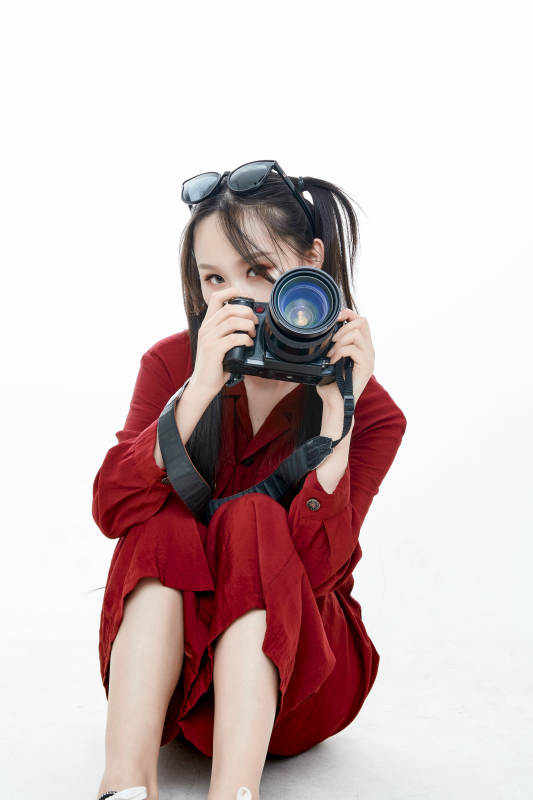 手持相机的亚洲戴墨镜年轻少女的肖像人像图片