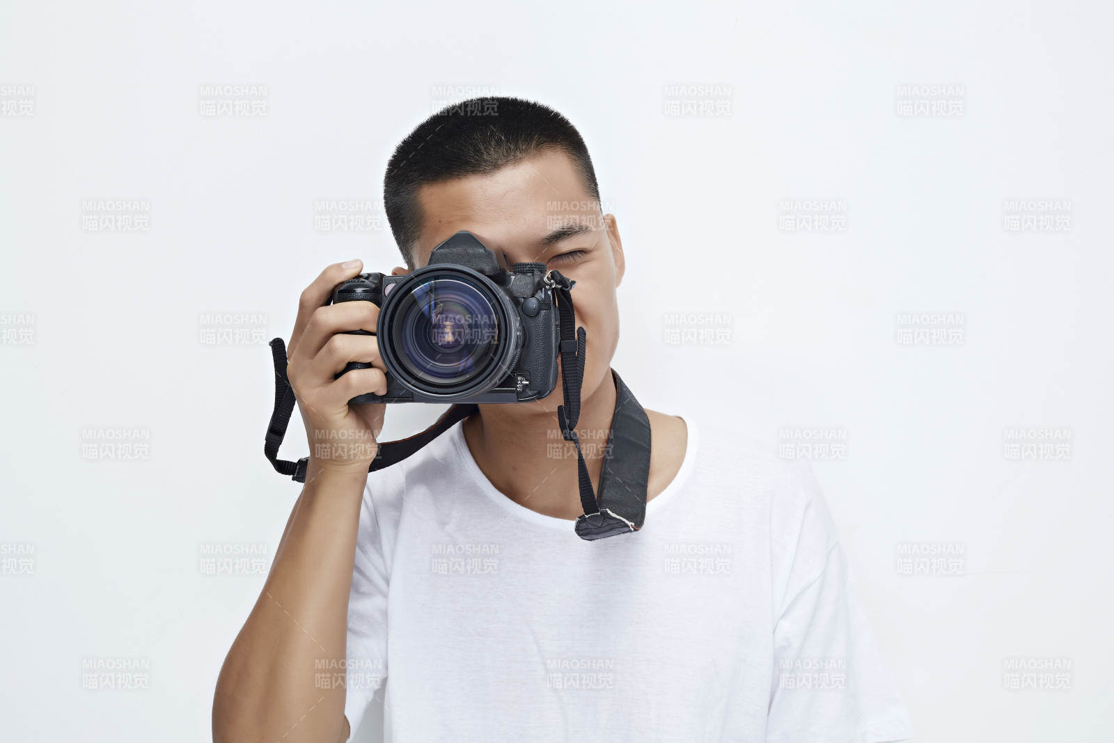 白色背景下手持照相机的亚洲男性摄影师图片
