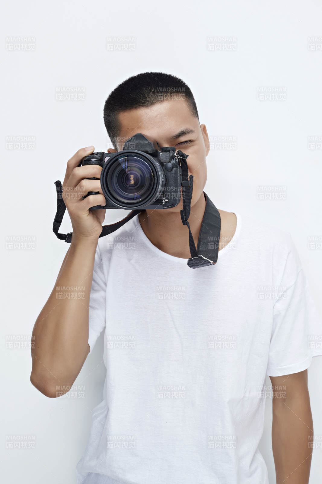 白色背景下手持照相机的亚洲男性摄影师图片