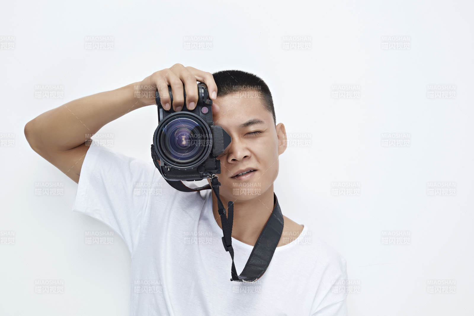 白色背景下手持照相机的亚洲男性摄影师图片