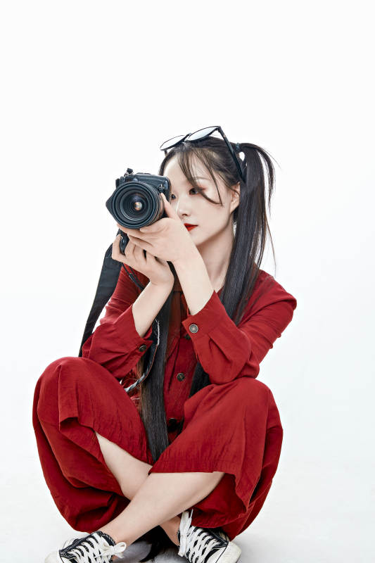 手持相机的亚洲戴墨镜年轻少女的肖像人像图片