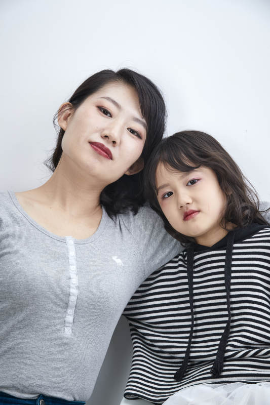 白色背景的美丽妈妈与可爱女儿亲子人像图片