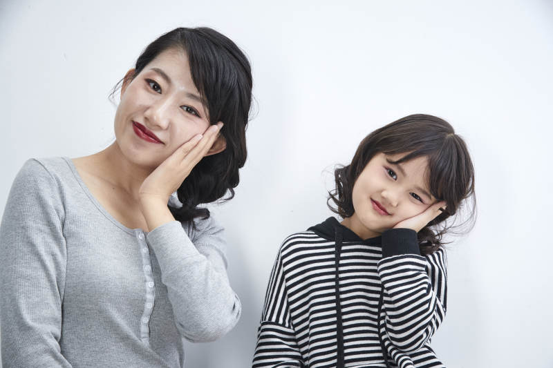 白色背景的美丽妈妈与可爱女儿亲子人像图片