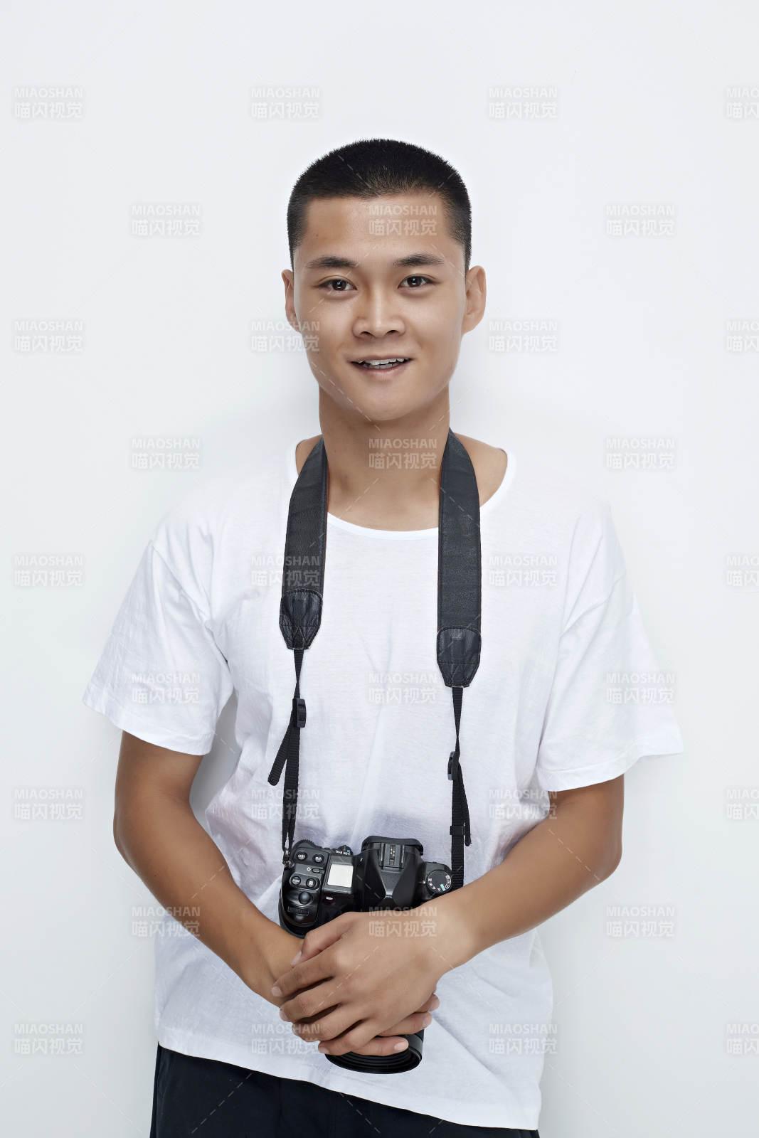 白色背景下手持照相机的亚洲男性摄影师图片