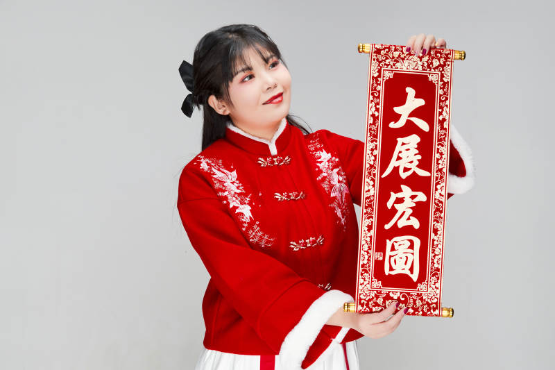 手持春联身穿喜庆汉服的可爱少女图片