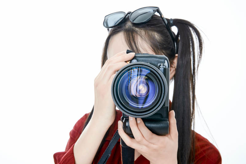 手持相机的亚洲戴墨镜年轻少女的肖像人像图片