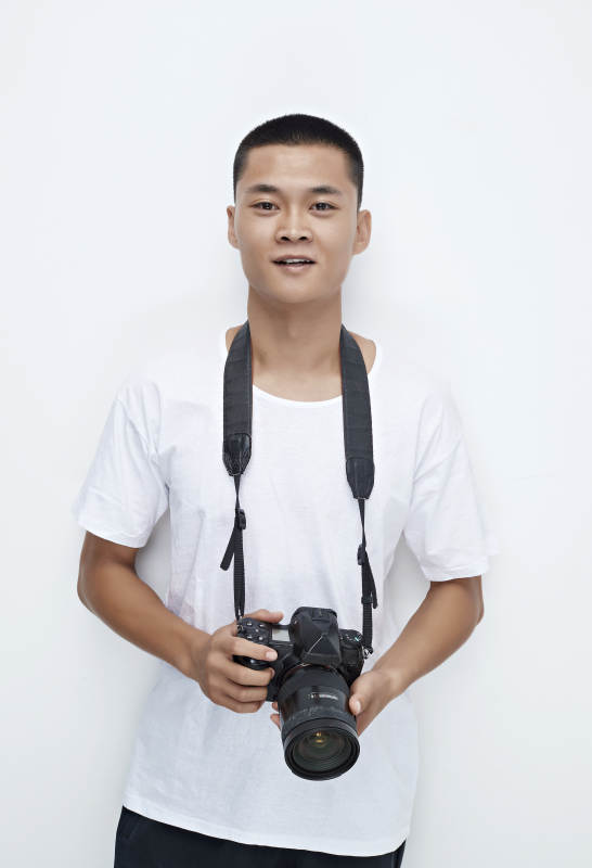 白色背景下手持照相机的亚洲男性摄影师图片