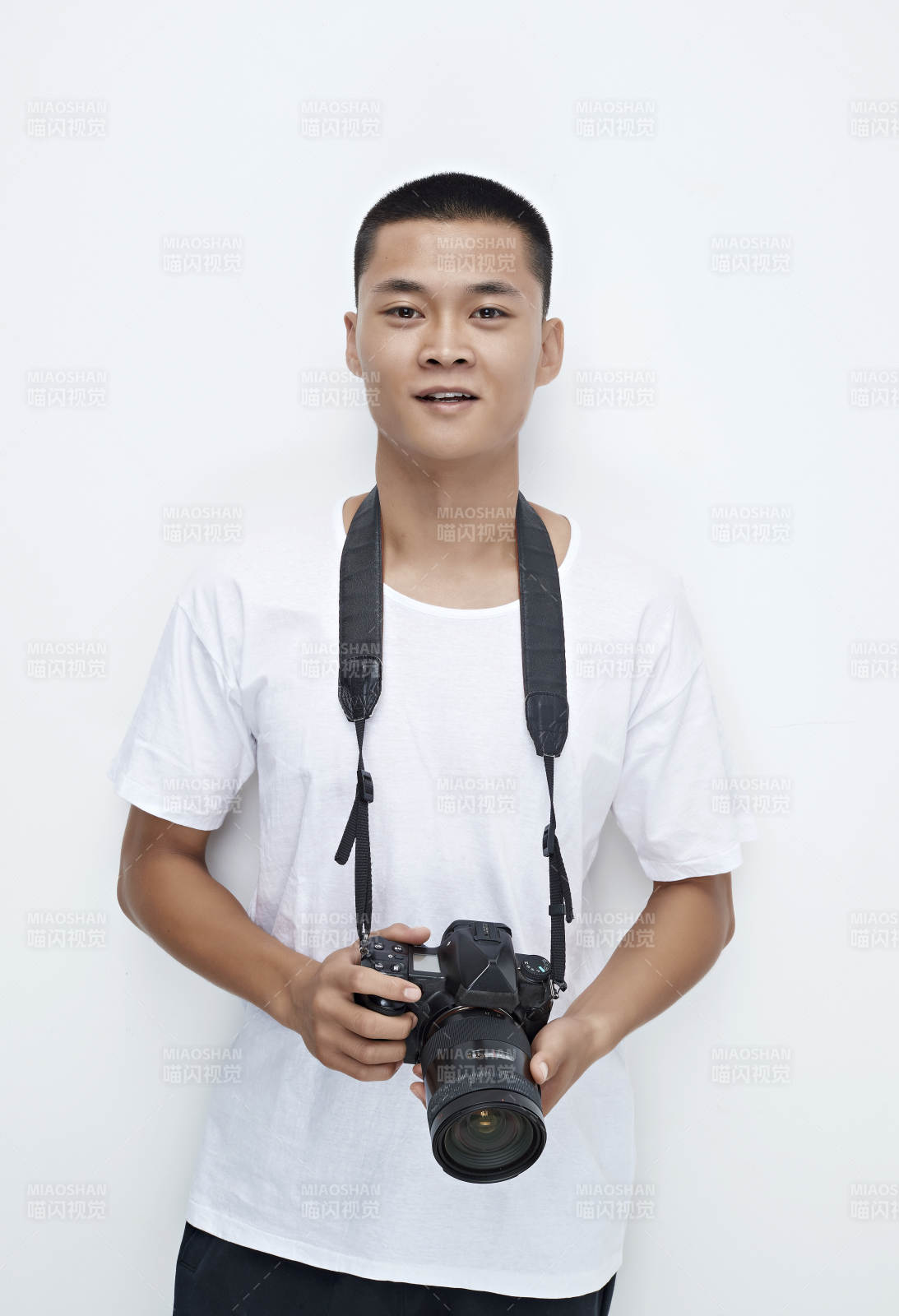 白色背景下手持照相机的亚洲男性摄影师图片