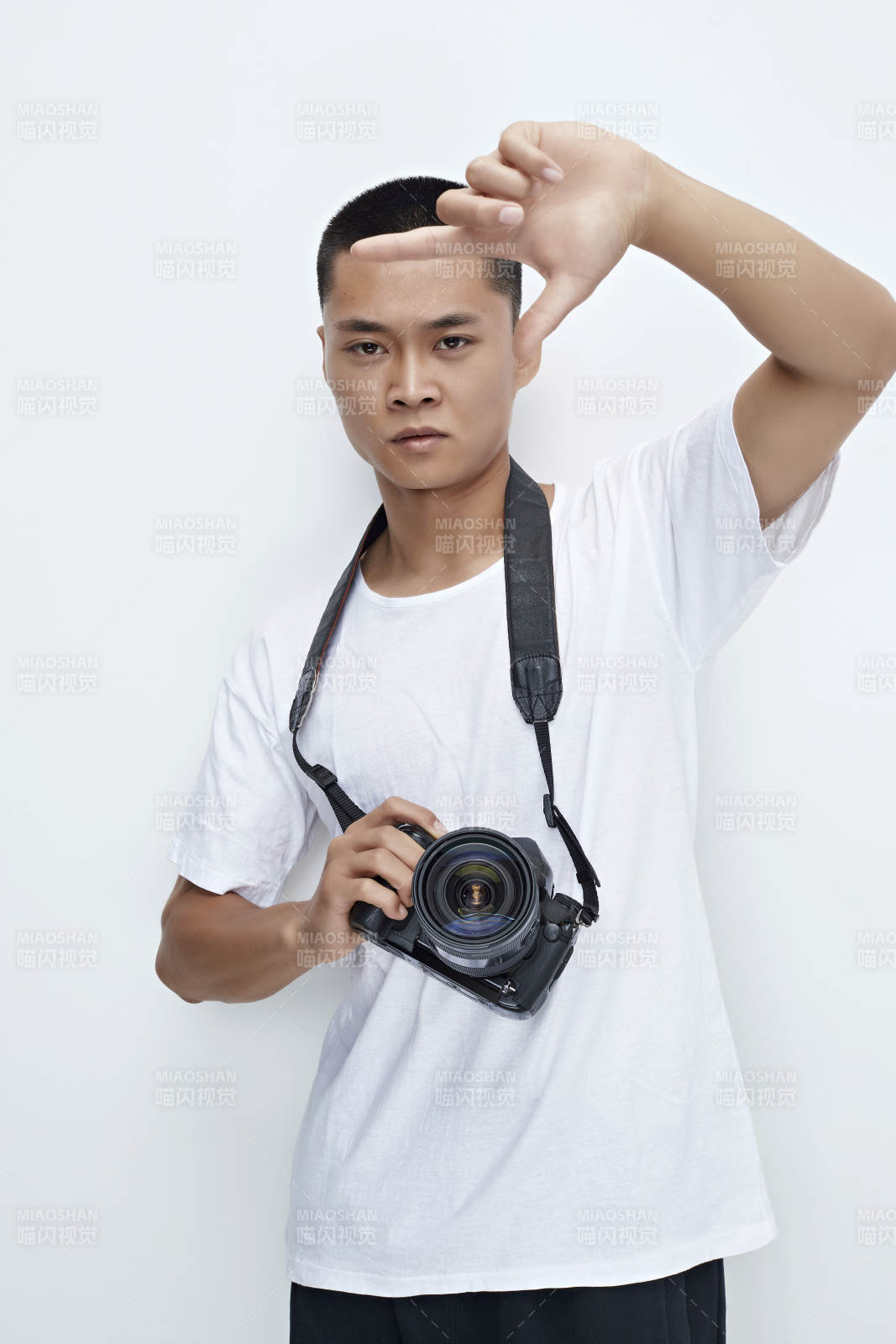 白色背景下手持照相机的亚洲男性摄影师图片