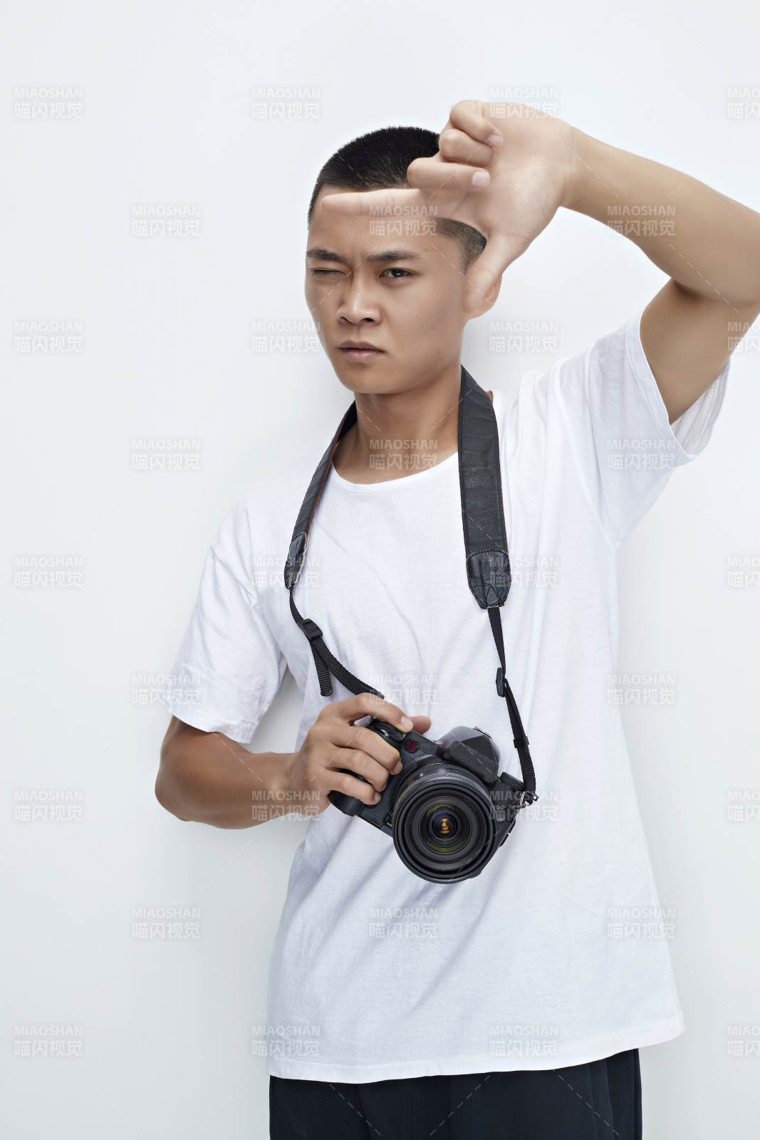 白色背景下手持照相机的亚洲男性摄影师图片