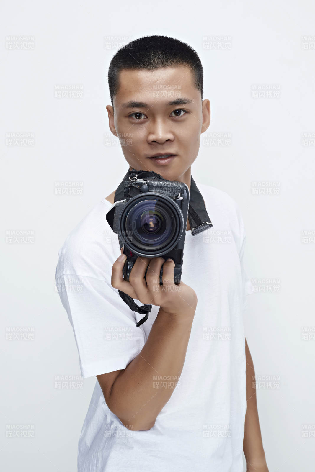 白色背景下手持照相机的亚洲男性摄影师图片