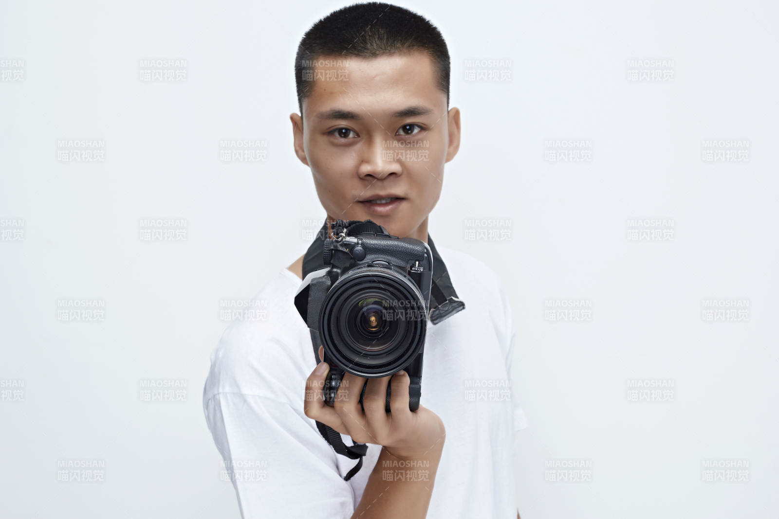 白色背景下手持照相机的亚洲男性摄影师图片