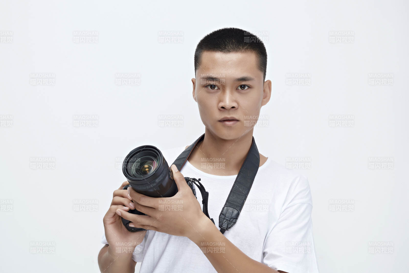 白色背景下手持照相机的亚洲男性摄影师图片