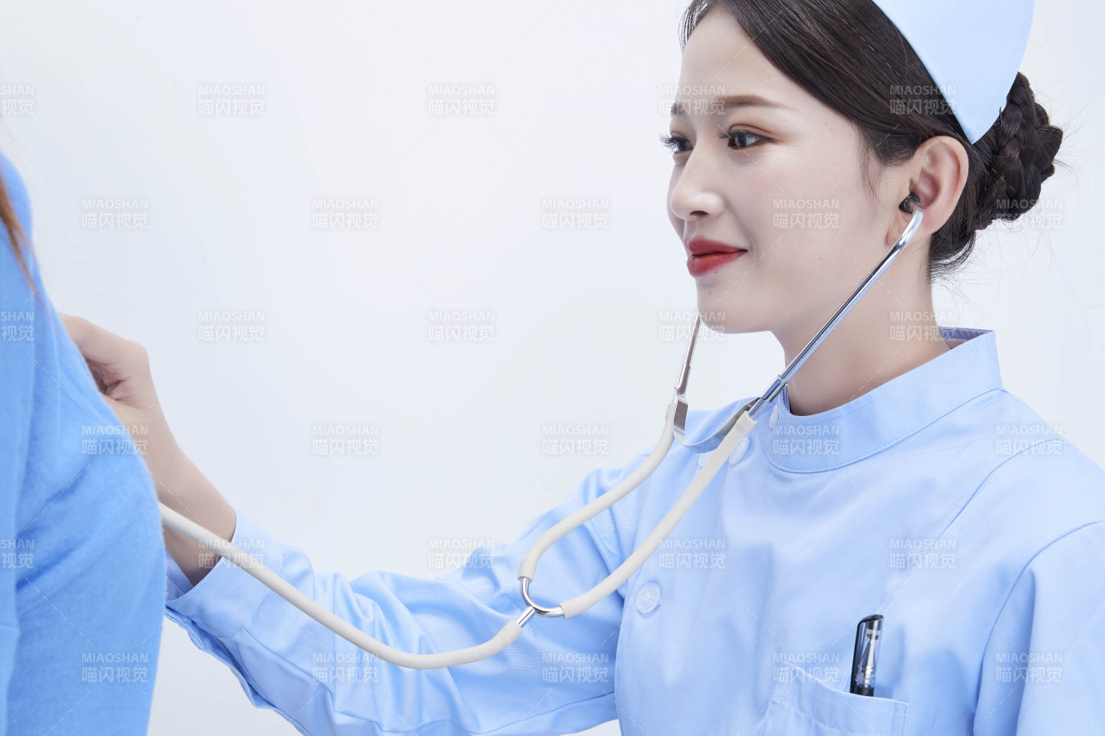 佩戴听诊器的女性医护人员为患者听诊检查图片