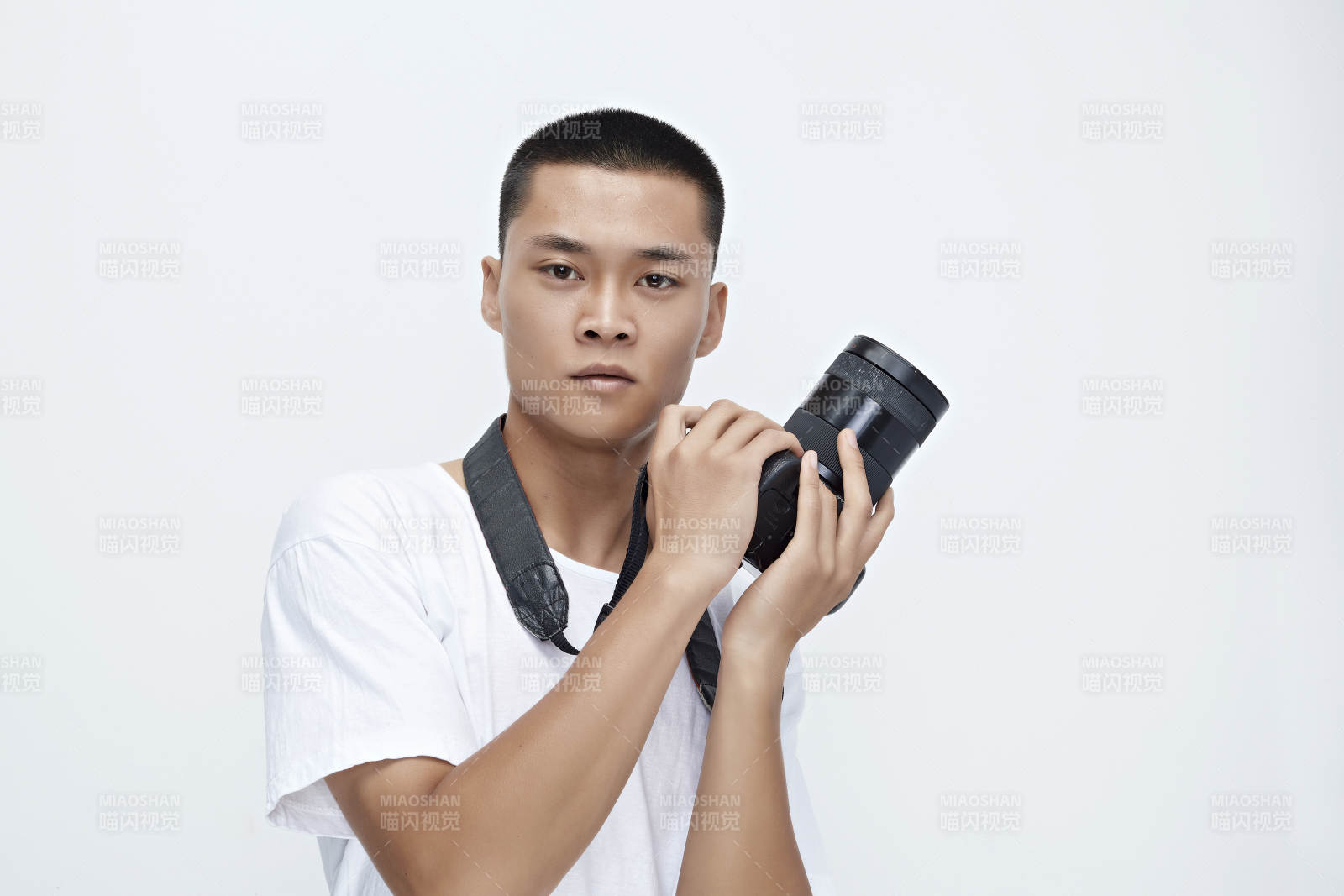 白色背景下手持照相机的亚洲男性摄影师图片