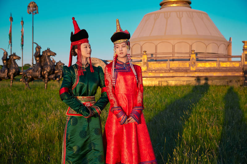 夕阳下草原蒙古大帐前穿蒙族服饰的美女图片