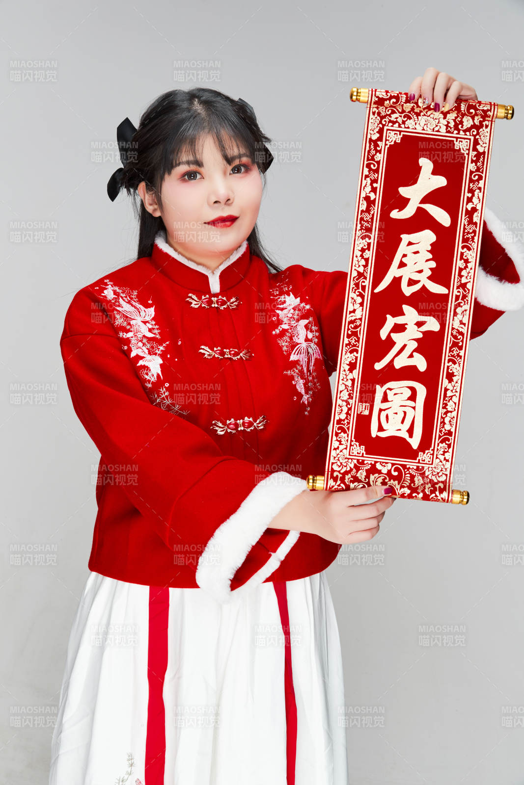 手持春联身穿喜庆汉服的可爱少女图片