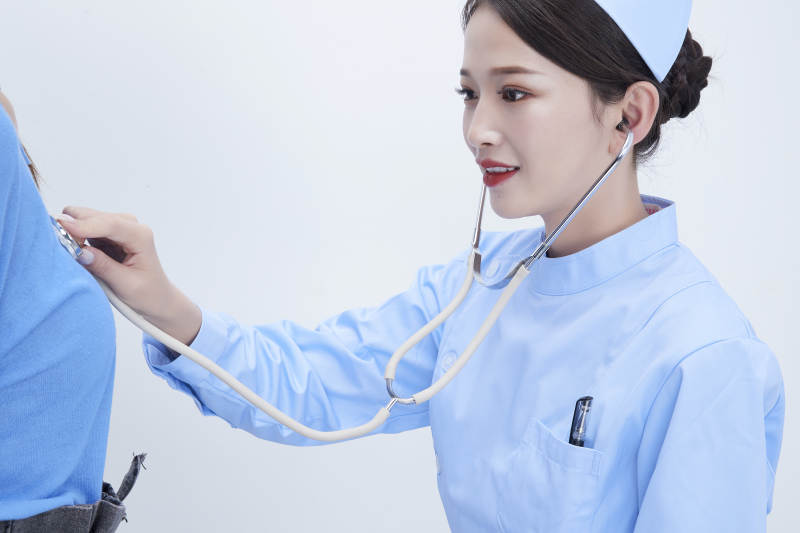 佩戴听诊器的女性医护人员为患者听诊检查图片