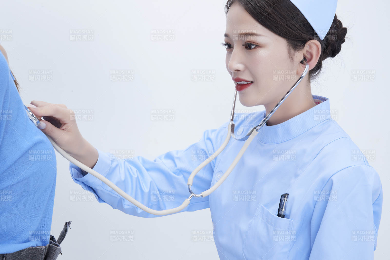 佩戴听诊器的女性医护人员为患者听诊检查图片