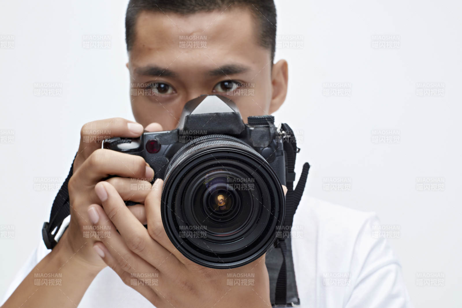 白色背景下手持照相机的亚洲男性摄影师图片