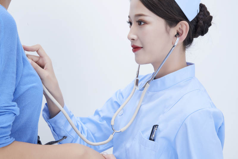 佩戴听诊器的女性医护人员为患者听诊检查图片