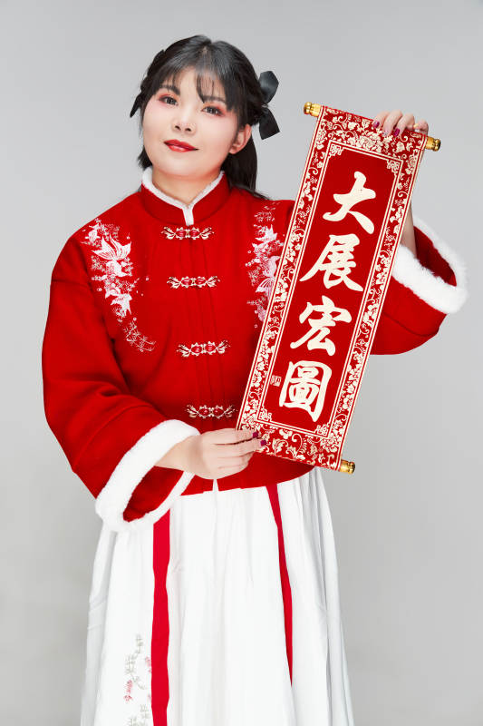 手持春联身穿喜庆汉服的可爱少女图片