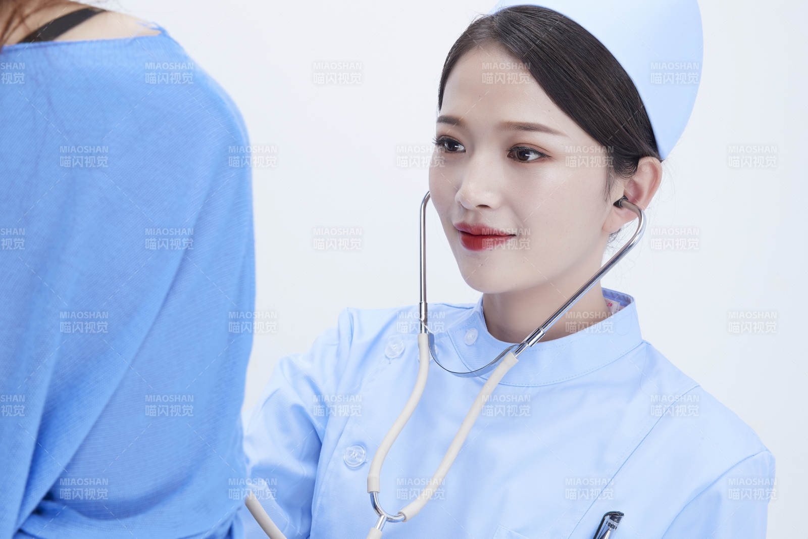 佩戴听诊器的女性医护人员为患者听诊检查图片