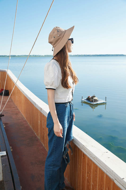 在湖畔木制帆船上的亚洲美女图片