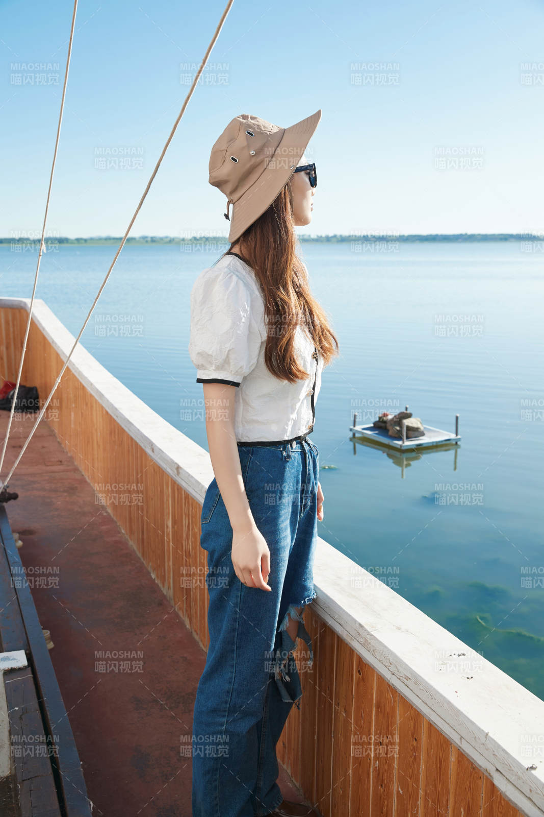 在湖畔木制帆船上的亚洲美女图片