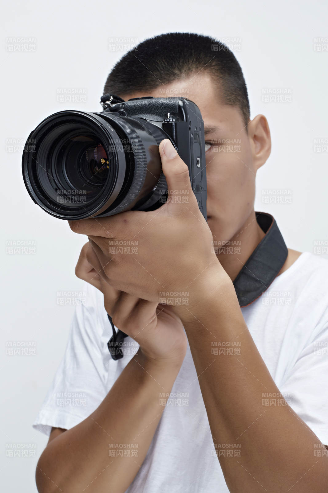 白色背景下手持照相机的亚洲男性摄影师图片
