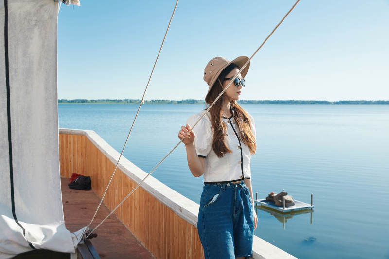 在湖畔木制帆船上的亚洲美女图片