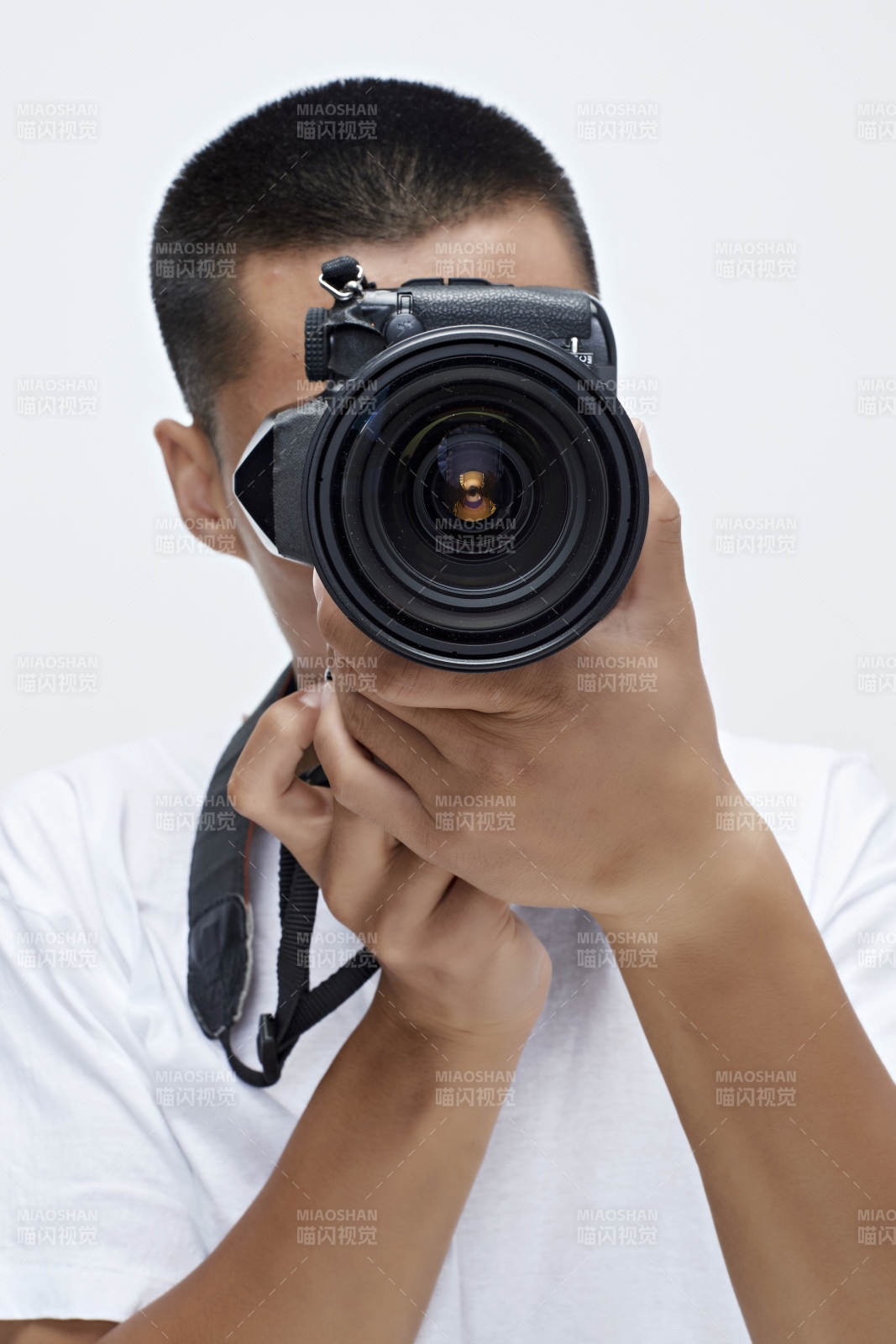白色背景下手持照相机的亚洲男性摄影师图片