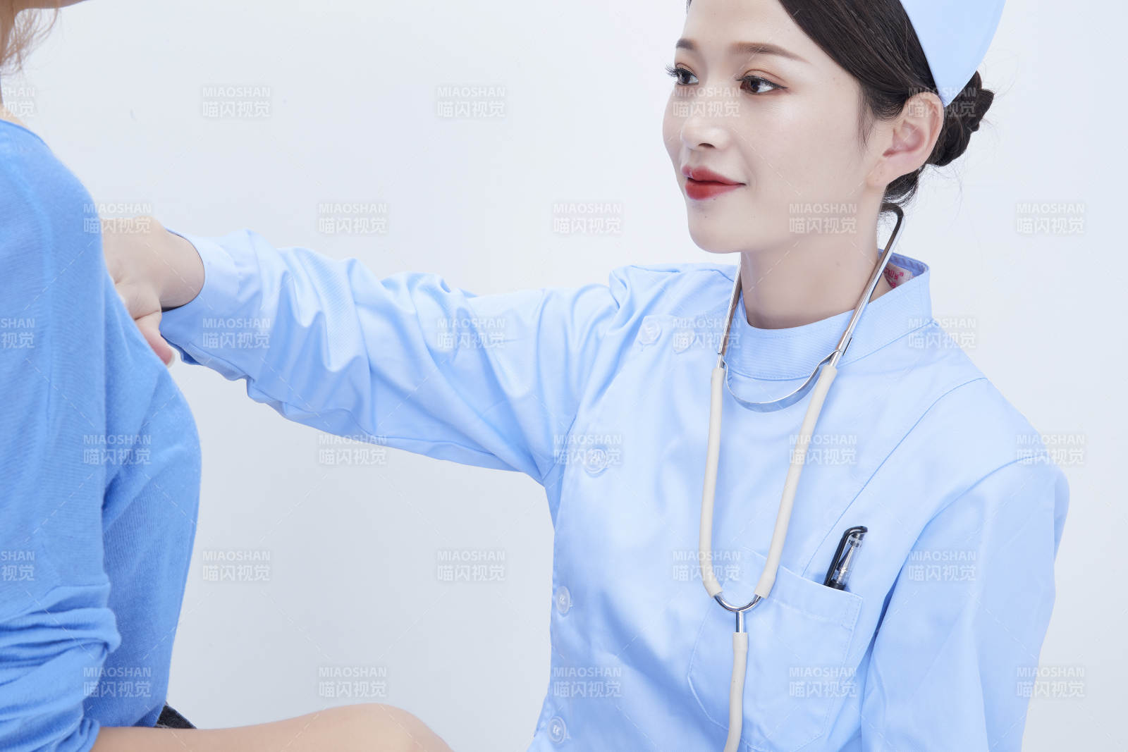 年轻的女性医护人员为患者进行身体按压检查图片