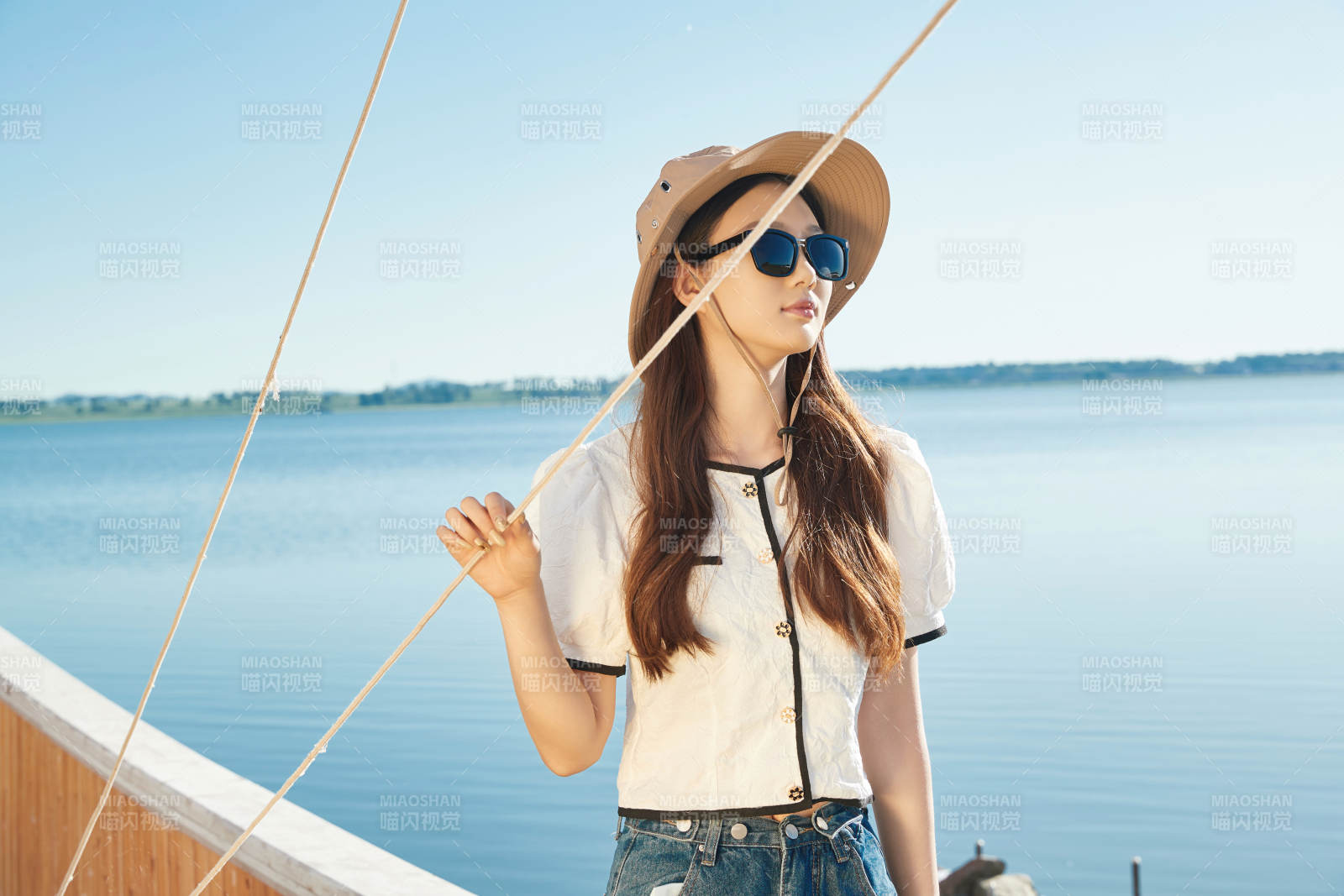 在湖畔木制帆船上的亚洲美女图片