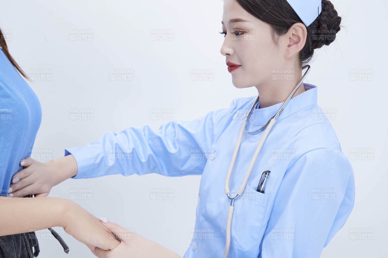 年轻的女性医护人员为患者进行身体按压检查图片