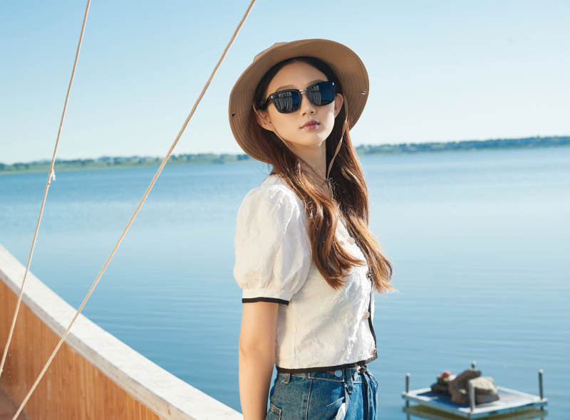 在湖畔木制帆船上的亚洲美女图片